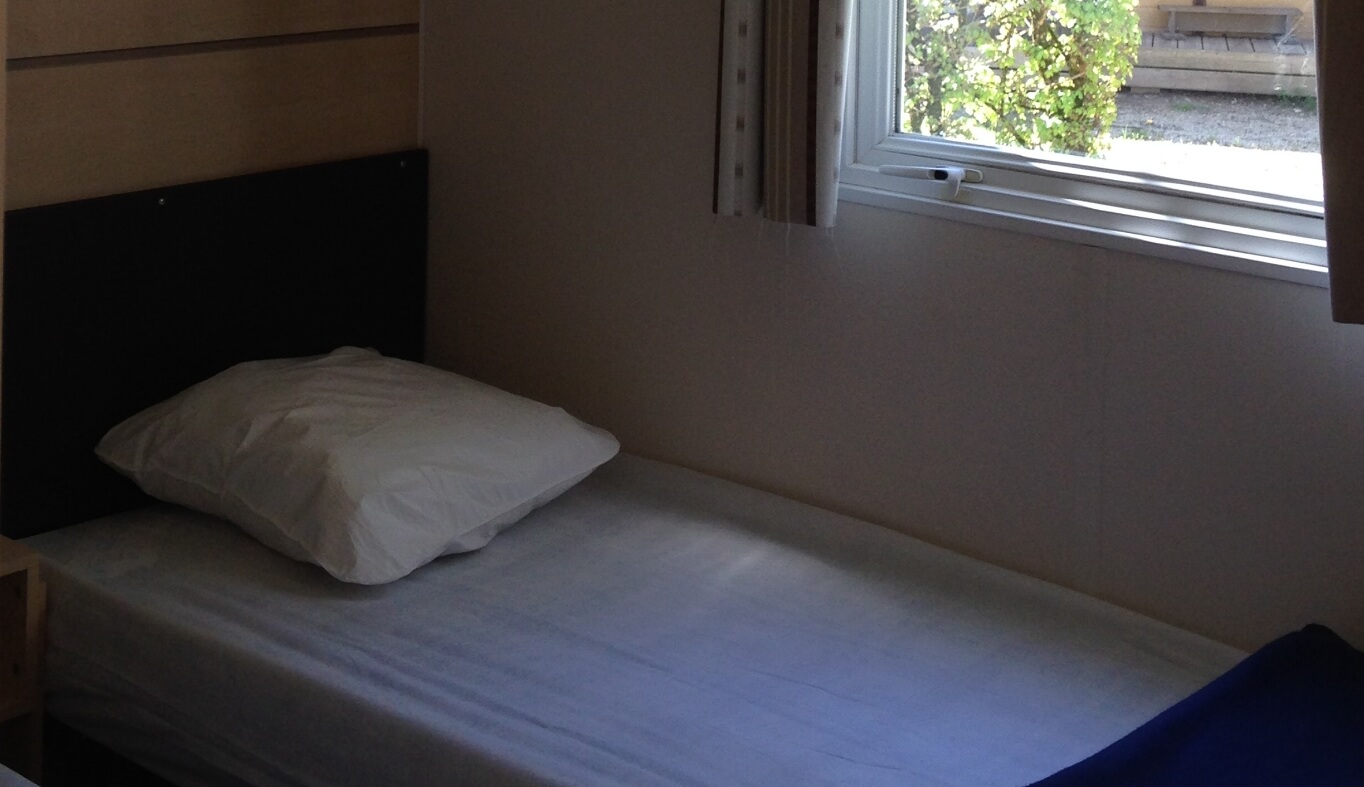 Chambre avec 2 lits une place du mobil-home Loggia dans le Jura en location au Camping le Val d’Amour