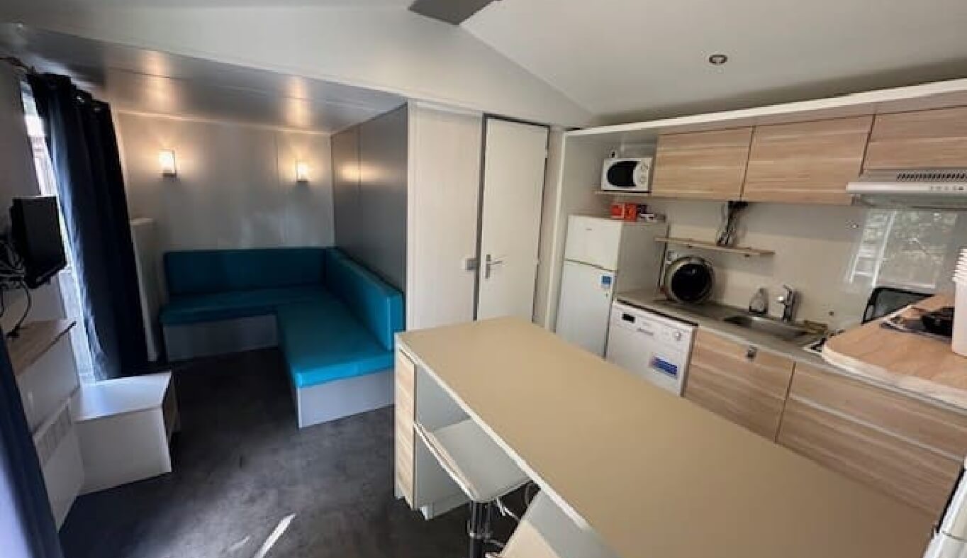 La cuisine et coin séjour du mobil-home O’hara 784 dans le Jura en location au Camping le Val d’Amour
