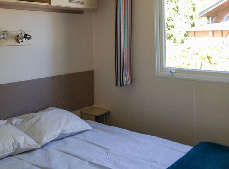 Schlafzimmer mit Doppelbett Mobilheim Super Octalia Campingplatz Le Val d'Amour im Jura