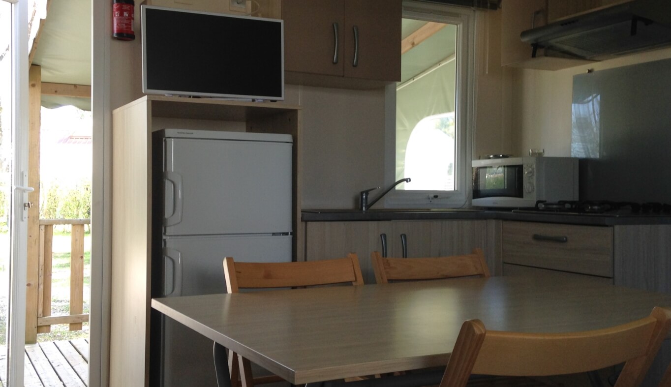 Coin repas du mobil-home Super Titania dans le Jura en location au Camping le Val d’Amour