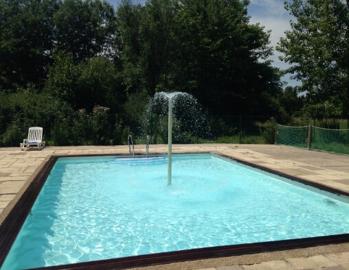 Petit bassin avec jet d’eau de l’espace aquatique du camping le Val d’Amour dans le Jura